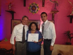 Two men and a woman holding a certificate