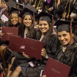 CityU Graduates Smiling while holding diplomas