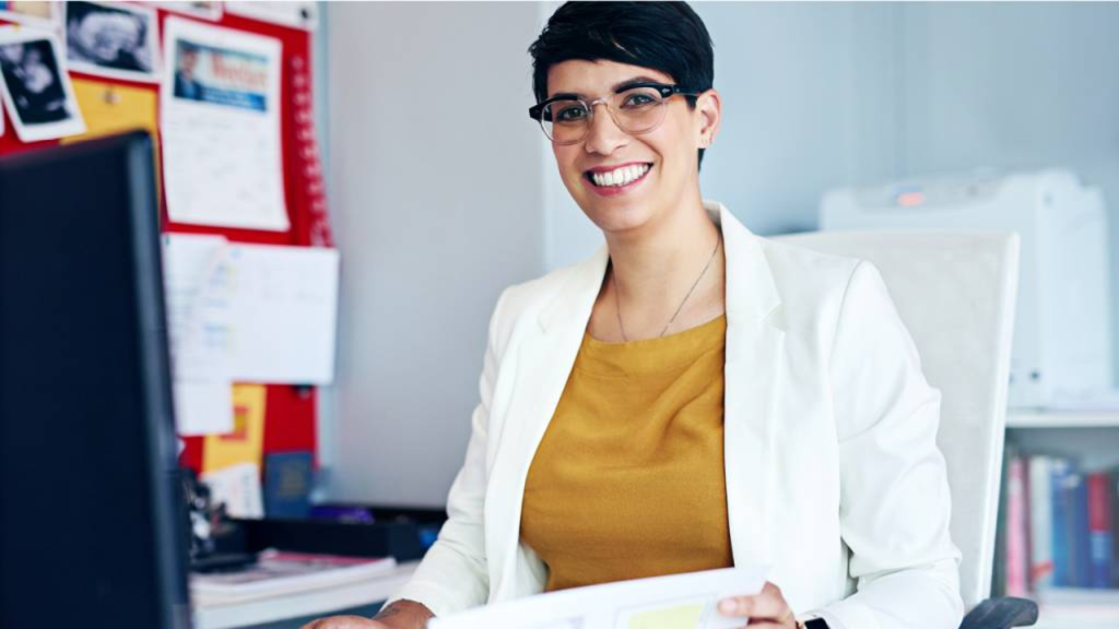 woman at desk smiling while working - bsba