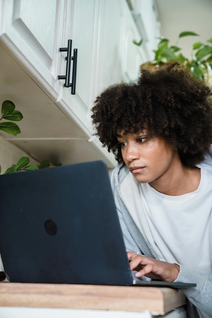 woman in the kitchen on a laptop researching if an mba is worth it