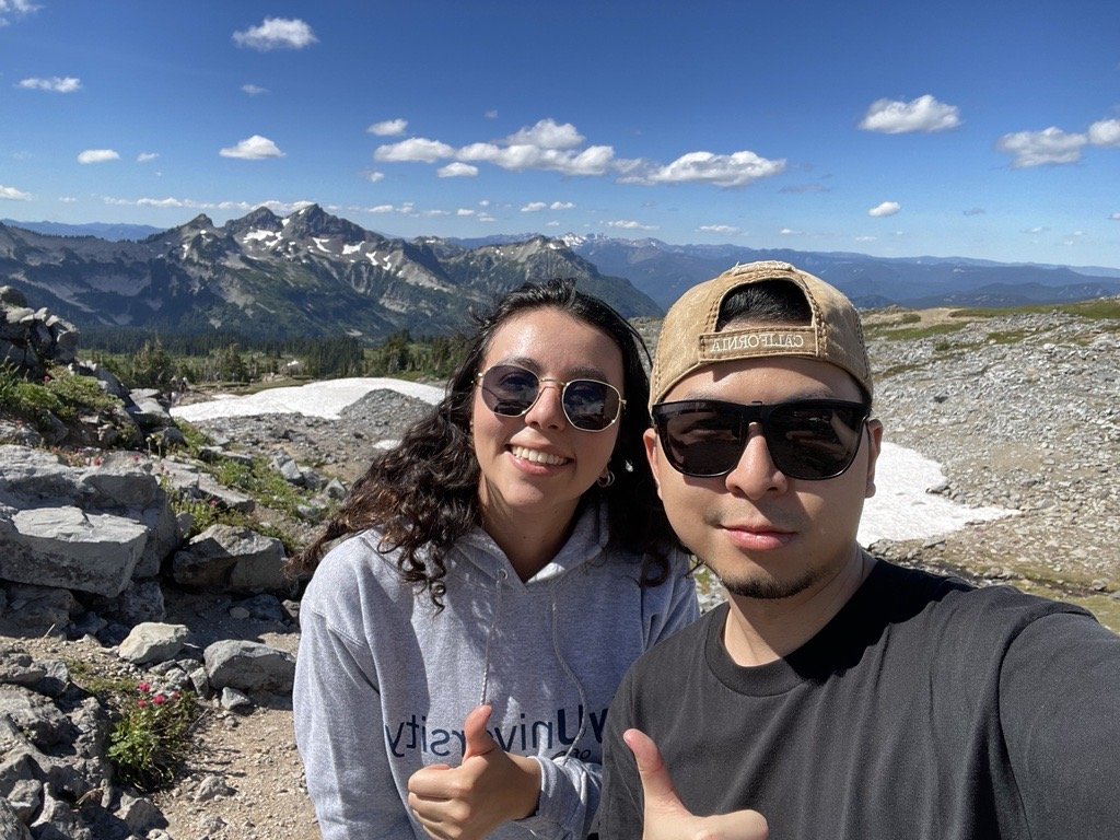 international students posing outside with view of sky and mountains in the background