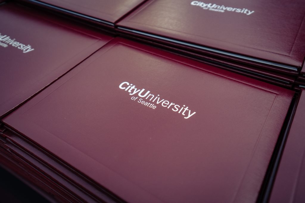 CityU padfolios stacked in rows on a table at commencement 2025.