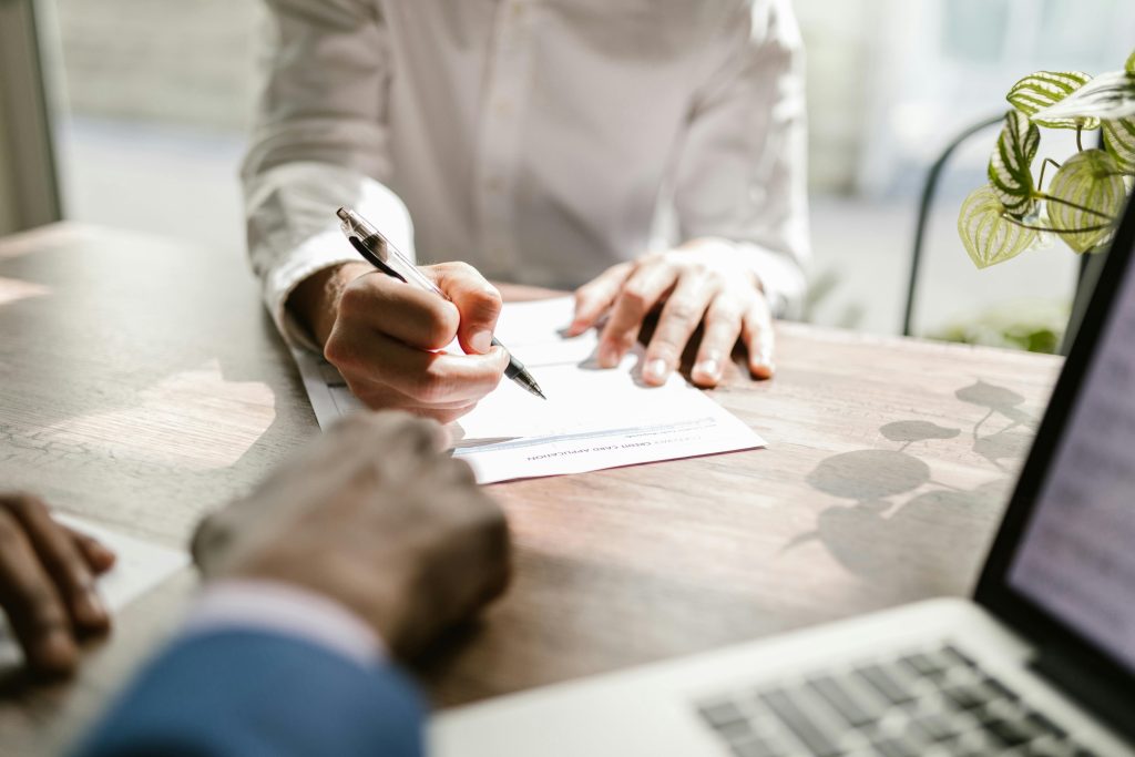 business people sitting at a desk signing documents after negotiation