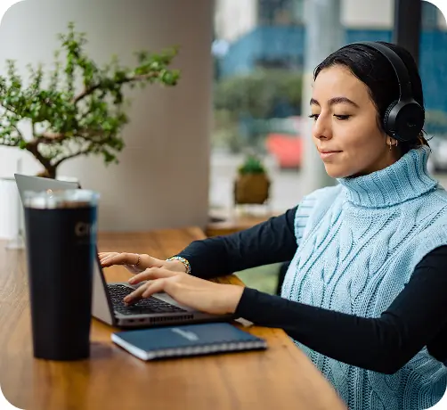 A student wearing headphones while studying in a quiet space.